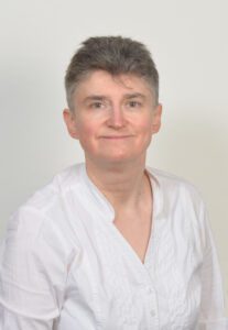 Dr. med. Astrid Schwarz, eine weiße Frau mit kurzen Haaren, trägt ein weißes Hemd und lächelt in die Kamera.