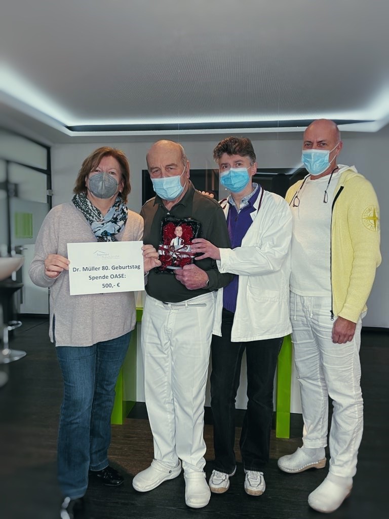 Dr. Bruckhaus-Walter, Dr. Schwarz und Dr. Müller halten gemeinsam ein Schild hoch mit der Aufsachrift "Dr. Müller 80. Geburtstat, Spende OEASE: 500 Euro"..