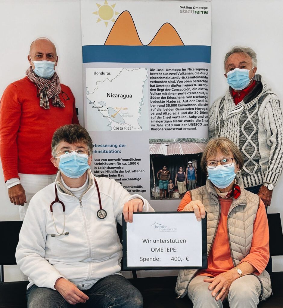 Dr. Bruckhaus-Walter und Dr. Schwarz halten gemeinsam mit zwei Personen von OMETEPE ein Schild hoch mit der Aufschrift "Wir unterstützen den Ometepe: Spende: 400 Euro.".